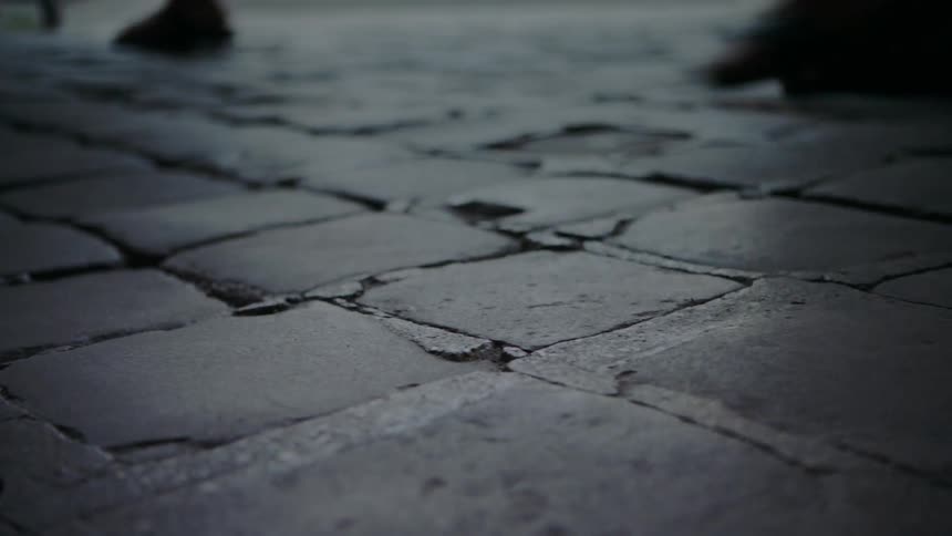 People walk on a stone sidewalk