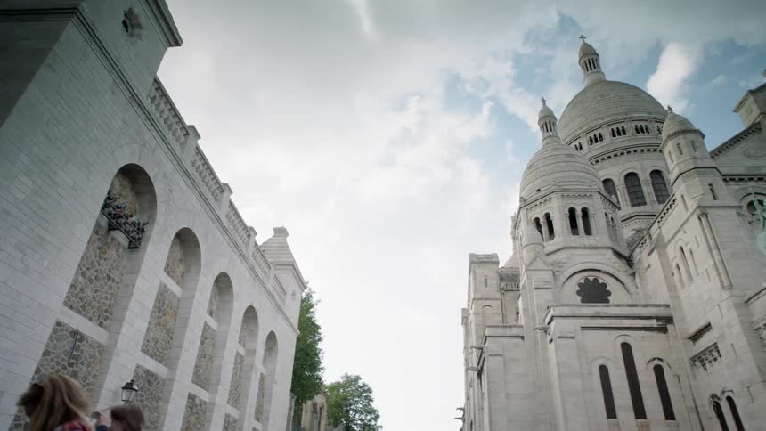 Clouds float over stone buildings