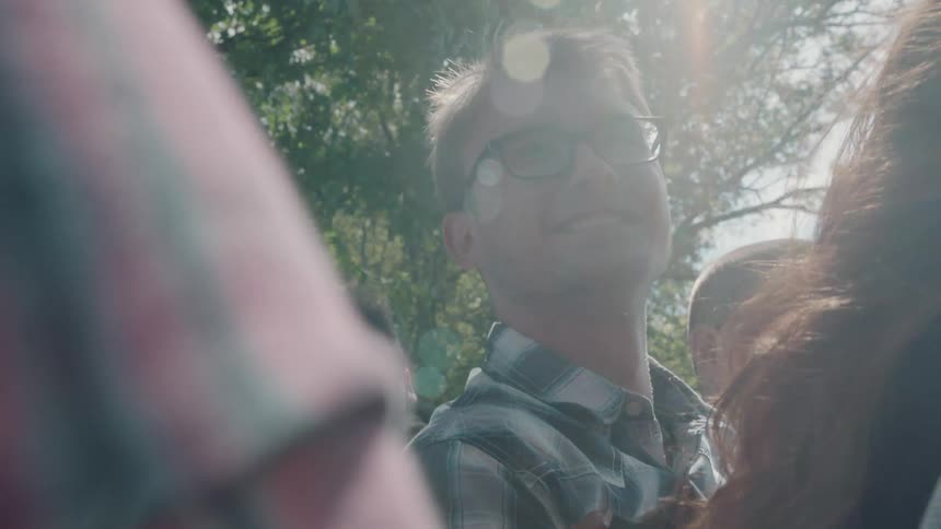 Smiling man spends time with friends outside on a sunny day