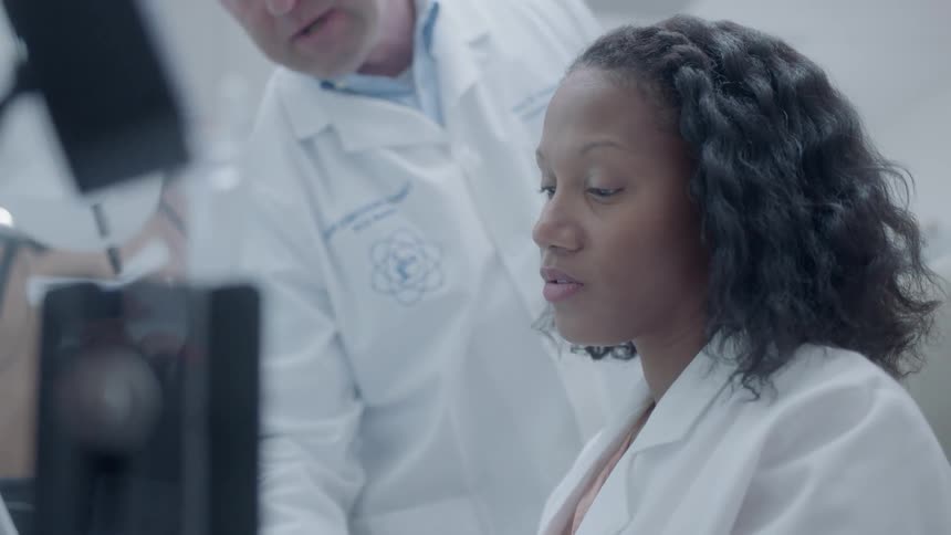 Two scientists talk while working