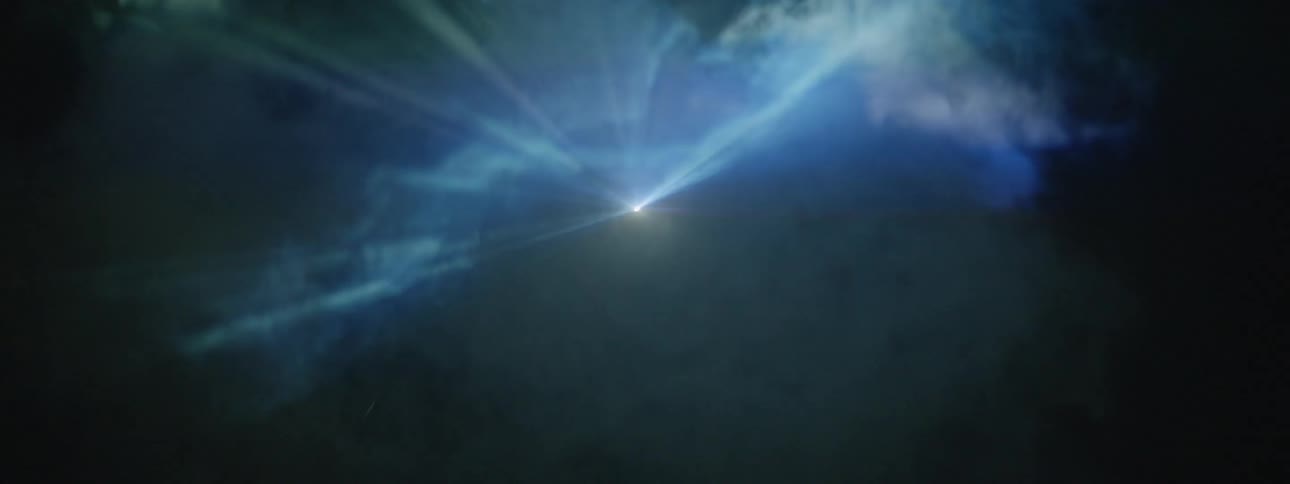 Smoke floats in front of strobe lights