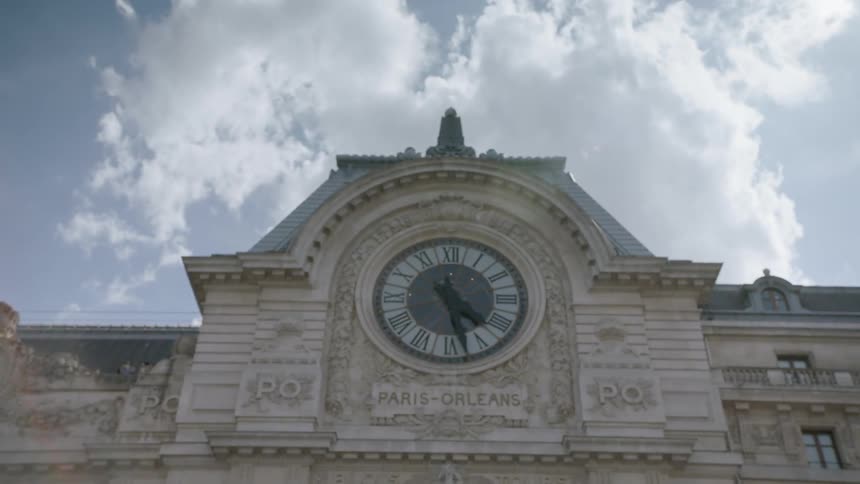Clouds float above a clock in paris