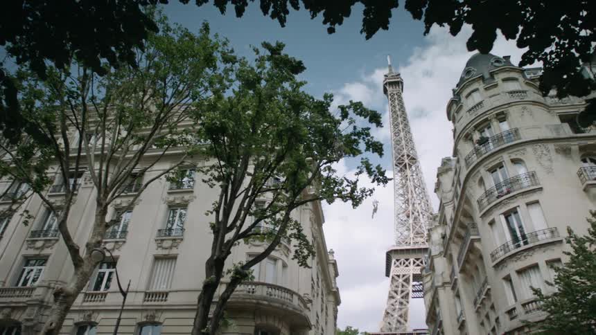 Looking up at the stone buildings and the eiffel tower