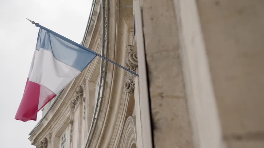 French flag hanging on the side of an old building