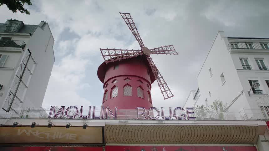 A windmill sits on the roof of a cabaret in paris