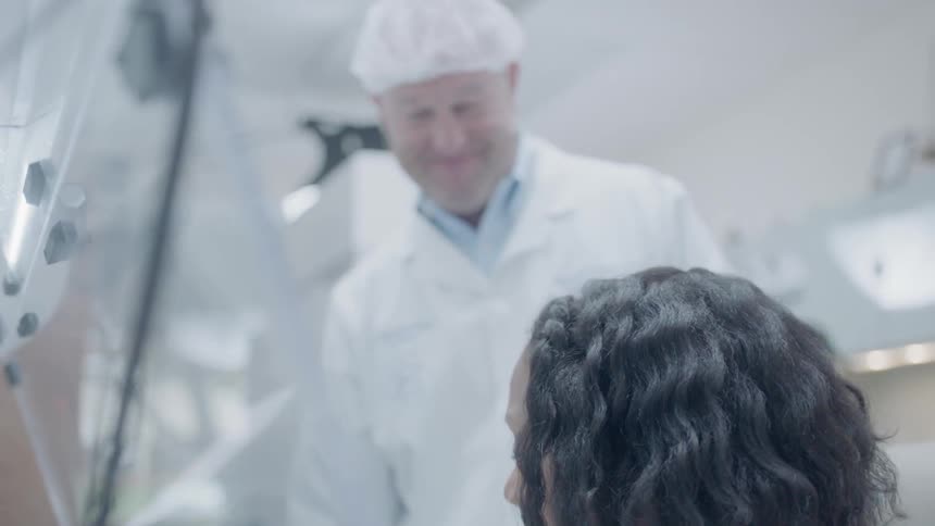A man and woman talk together in a lab