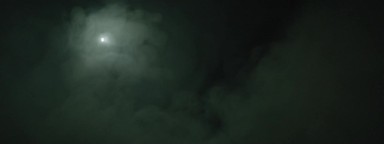 A light flashes and shines on smoke at night
