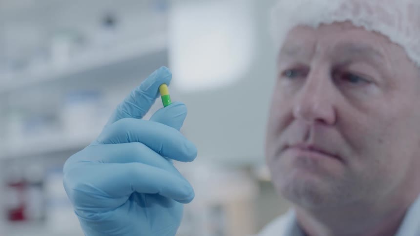 Pharmacist examines a pill