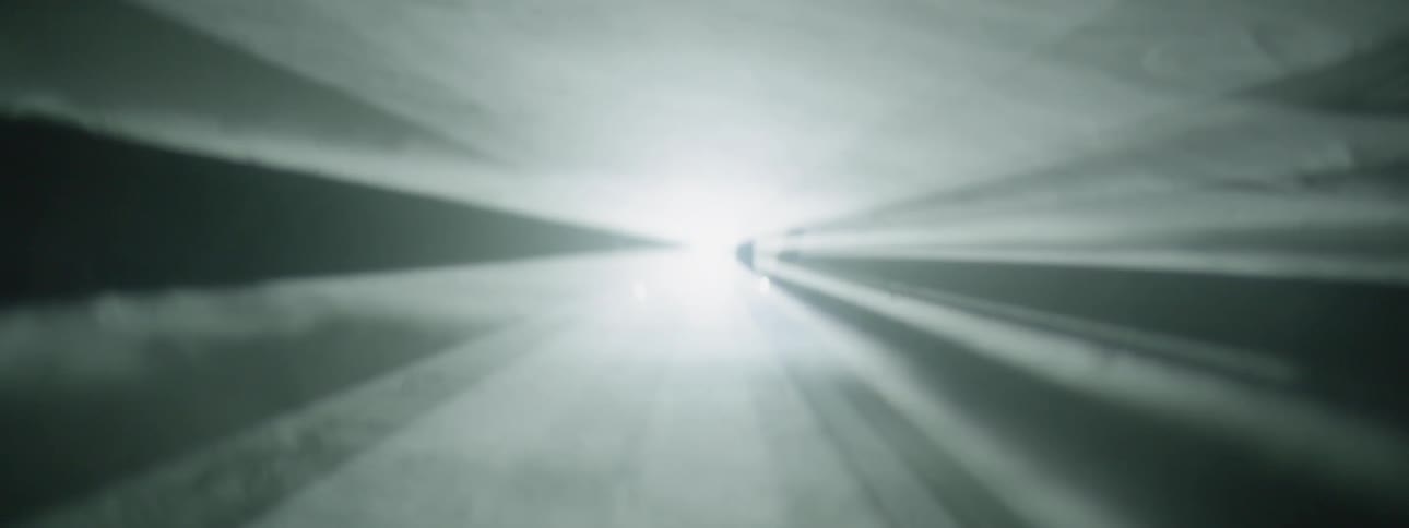Beams of light shining and being broken by a person's hand