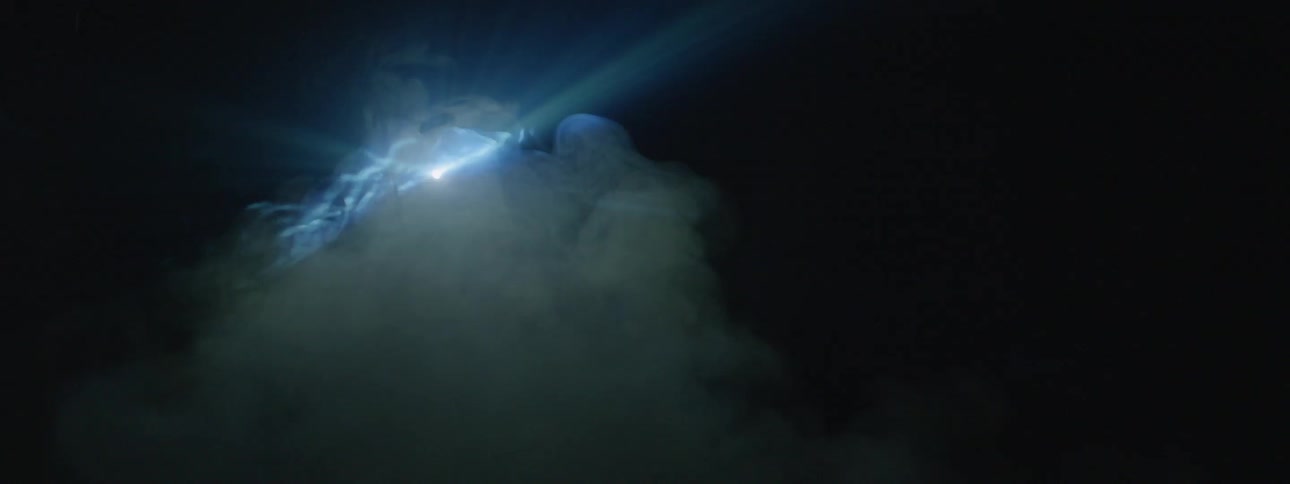 Smoke floats in front of a strobe light