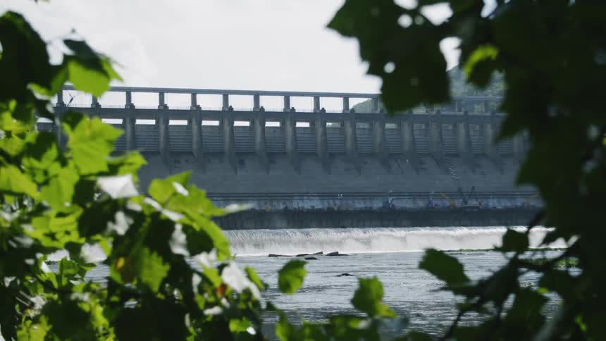 Water flows down a stream by a dam
