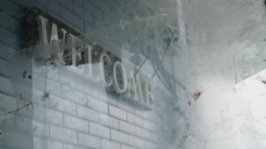 There is a sign on the brick wall that says welcome