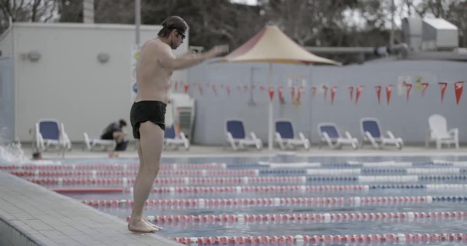 A swimmer dives into a pool