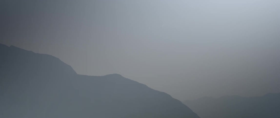 The ridge line of a hill is visible in the hazy sky