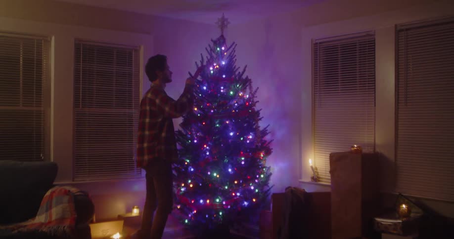 Man decorates christmas tree