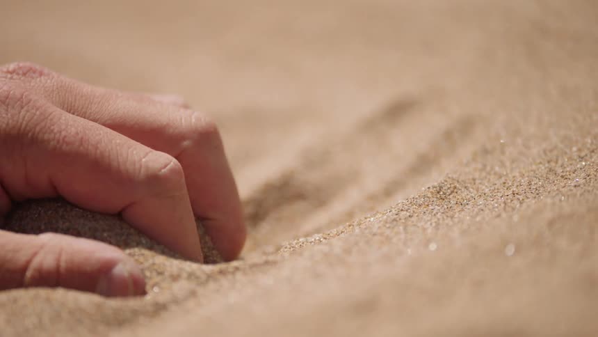 Hand grasps some sand