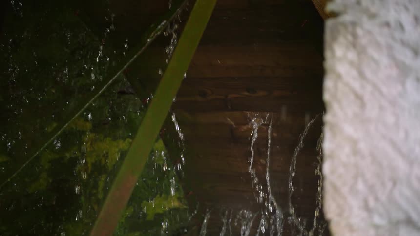 Water splashes off of a large wooden wheel