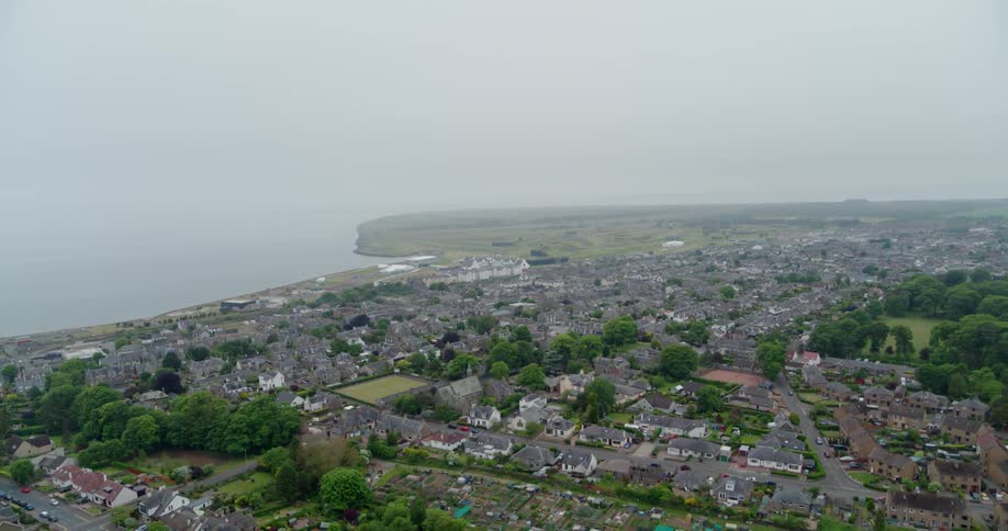 A coastal city is shown on a foggy day