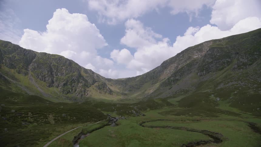 Green mountains and a river flowing through a valley on a cloudy day
