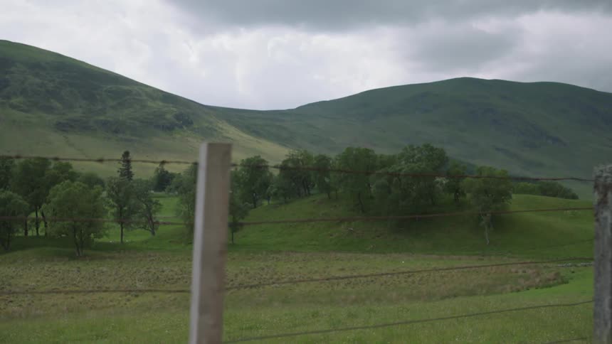 A fence blocks off land leading to the green hills