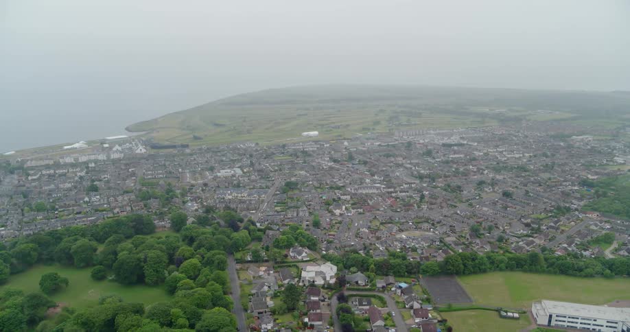 A coastal city is shown on a foggy day