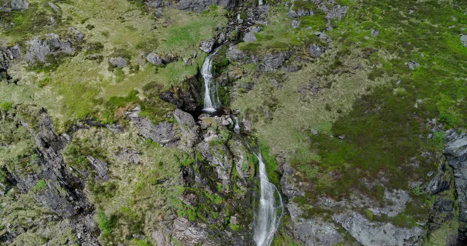 A waterfall is cascading down a mountainside during the day