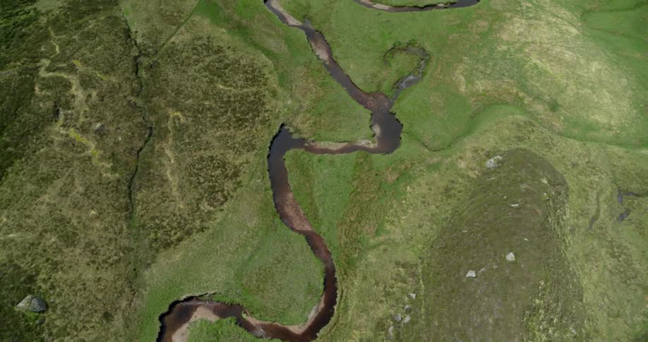 A river is winding its way through a valley during the day