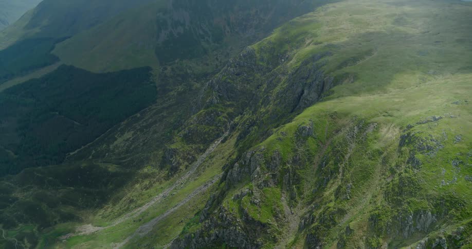 The long hills are covered with green below