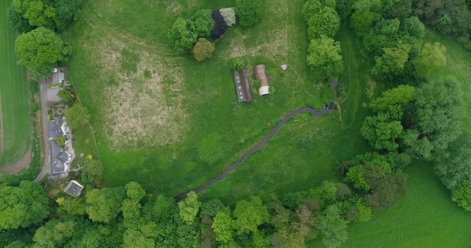 A river flows by rural buildings