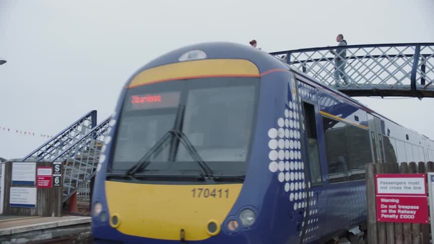 Train passes under a pedestrian bridge