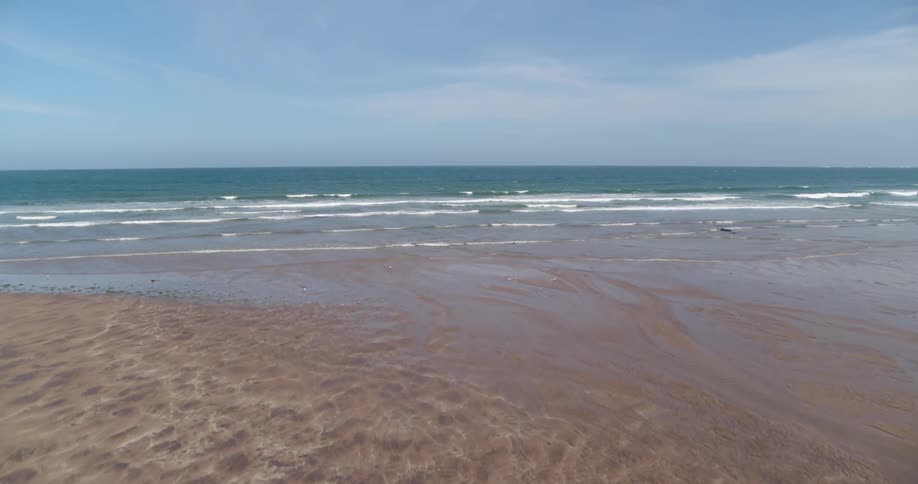 Ocean waves wash ashore a sandy beach