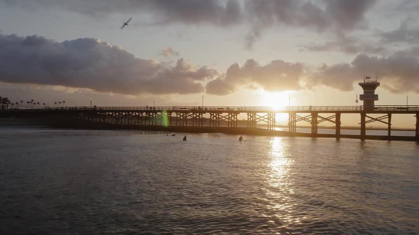 Sun sets over an ocean pier