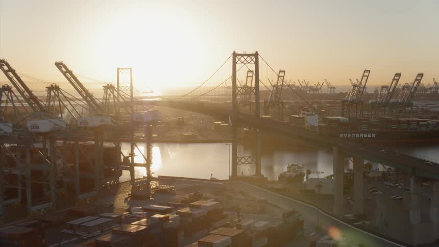 Cars drive on a city bridge at sunset