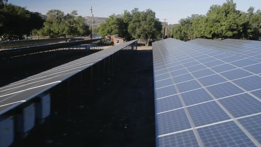 Solar panels sit in a rural field