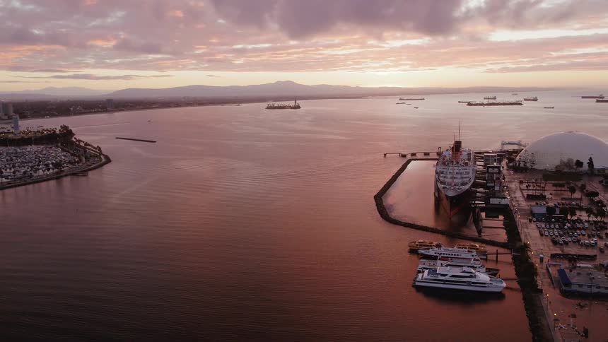 Ships float in a port at sunset