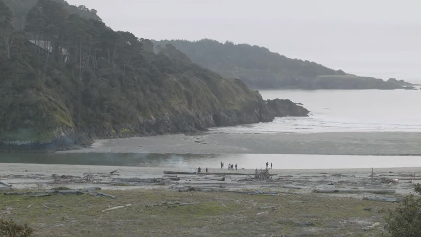 People stand on the beach shore