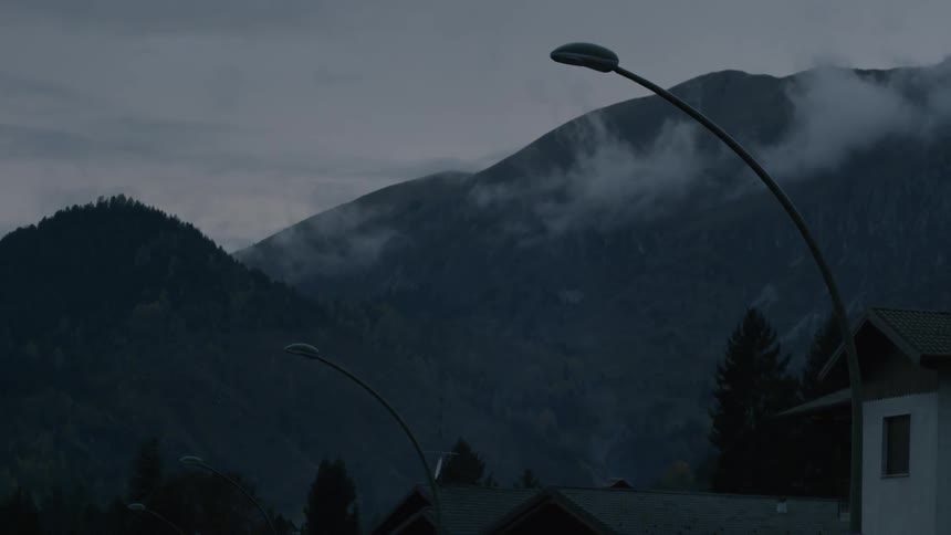 Clouds float around mountains at dusk