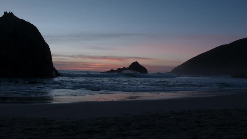 Waves roll into the shore at sunset