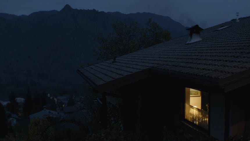 Light is shining from a house window at night