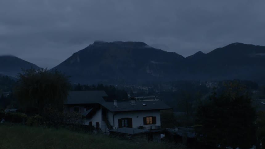 A house sits near mountains