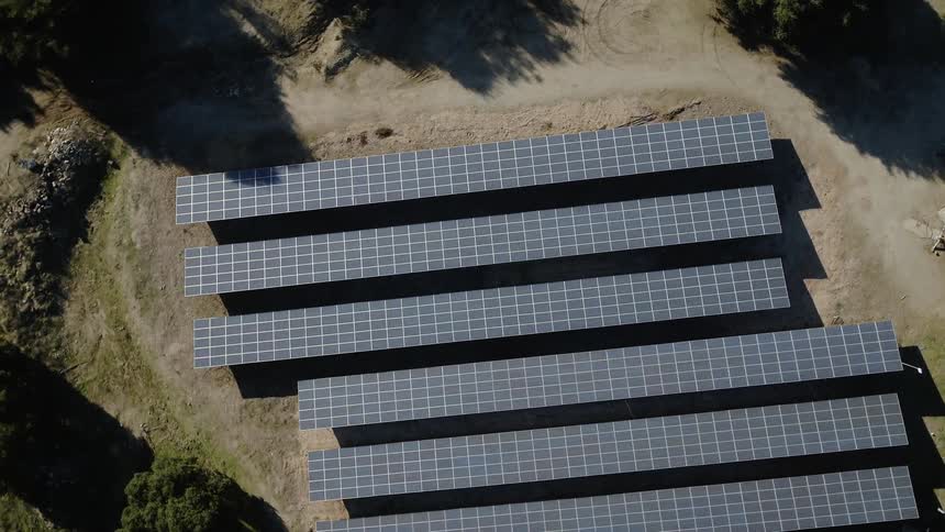 Solar panels sit in a rural field