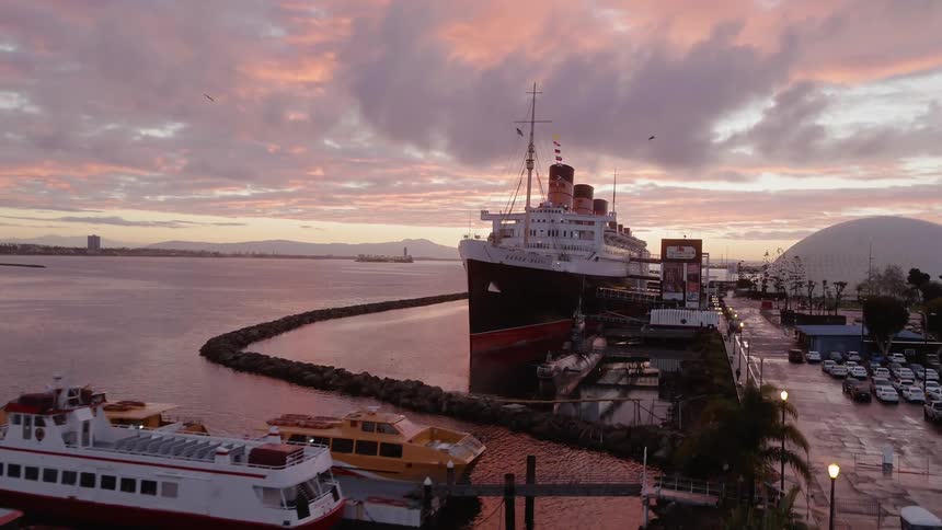 Ships float in a port at sunset