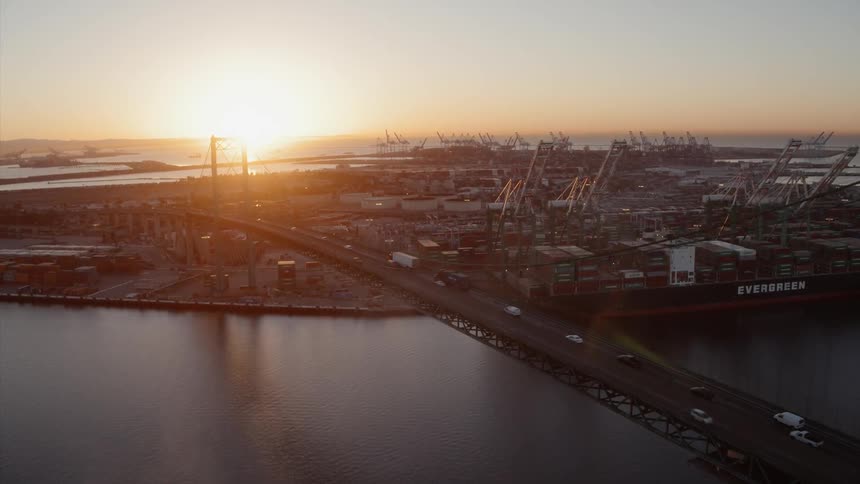 Cars drive on a city bridge at sunset