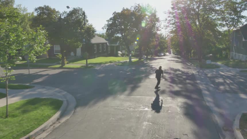 Aerial view of a man skateboarding down a street