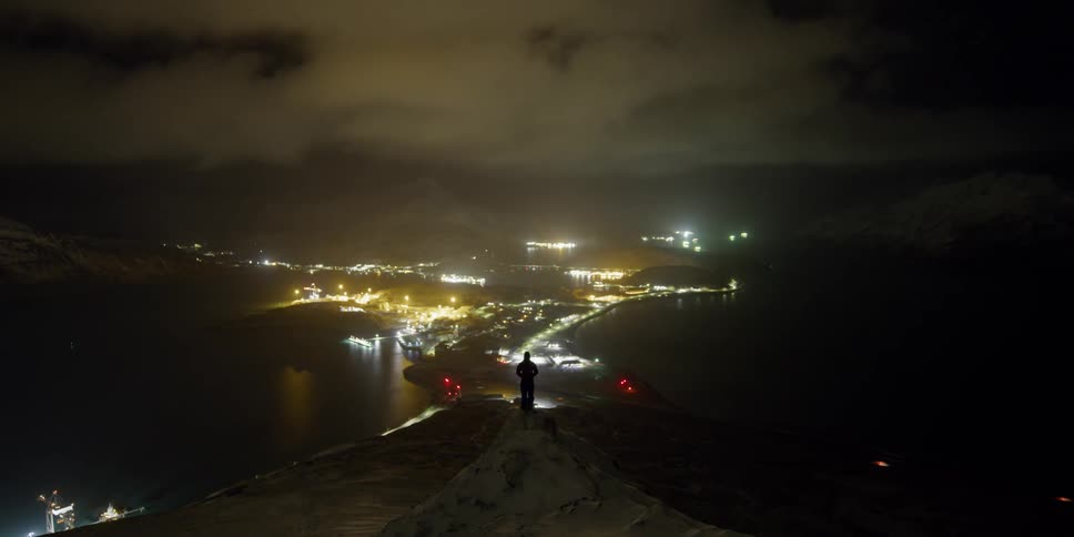 A man stands above a city timelapse