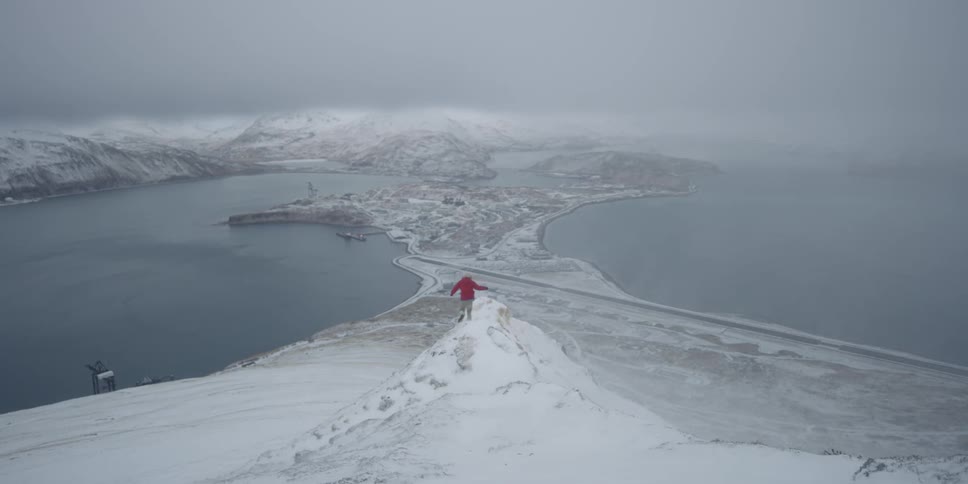 A man is running toward a snow-covered ridge in winter