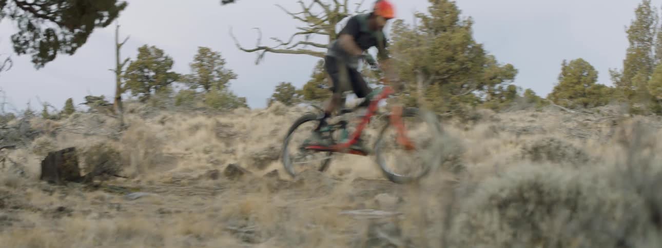 A bicyclist rides down a hill rapidly