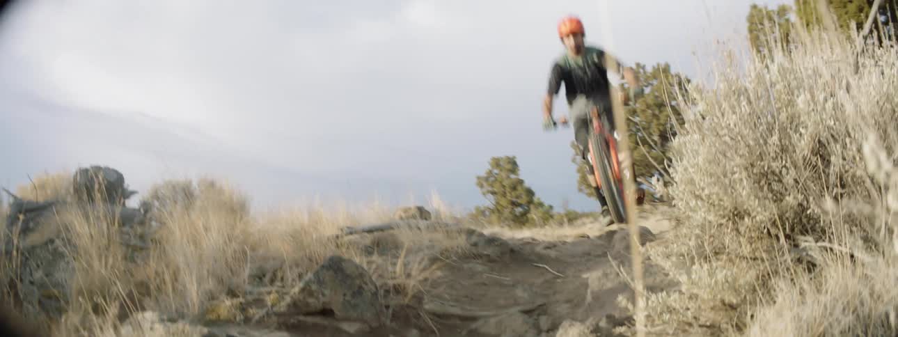 A bicyclist jumps over a rocky path