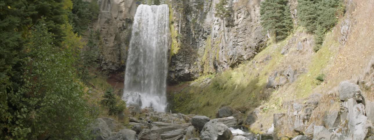 Water flows down the waterfall and splashes on the rocks