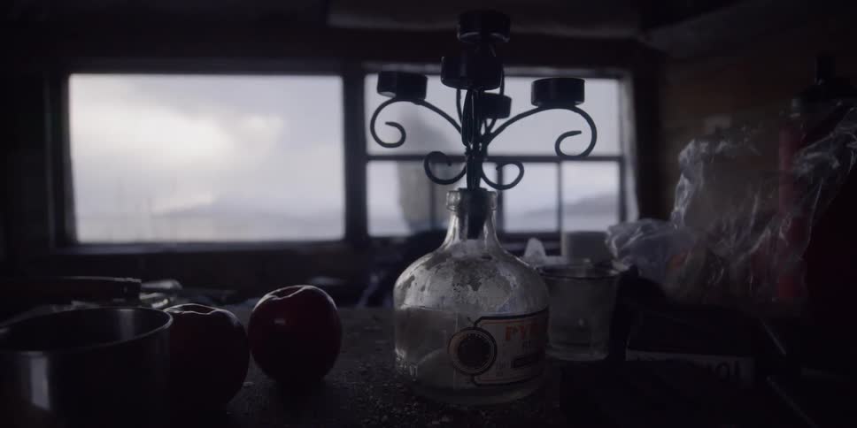 Someone approaches a house with apples on the table